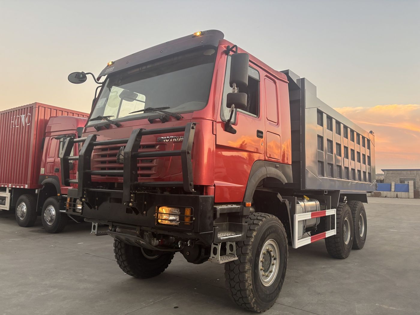Real photo · HOWO 6x6 all-wheel drive dump truck with red cab and grey tipper body, current vehicle photo