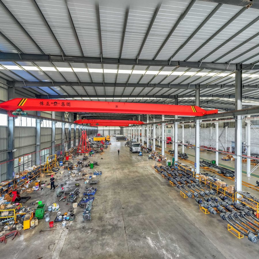 Long assembly hall with axles lined up under red overhead cranes