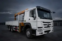 HOWO 6x4 truck-mounted crane with folded boom — illustrative studio image